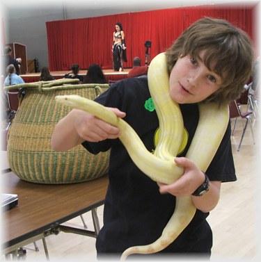 11 years old MIchel holds Mohini, a rare albino Columbian Red Tail Boa